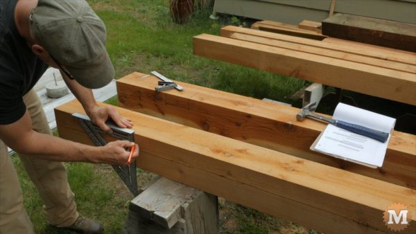 marking western red cedar posts with a large speed square and pencil