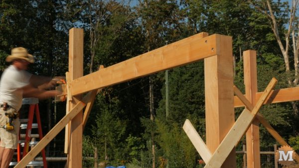 Installing first side girt with lag bolts - Timber Frame Pavilion