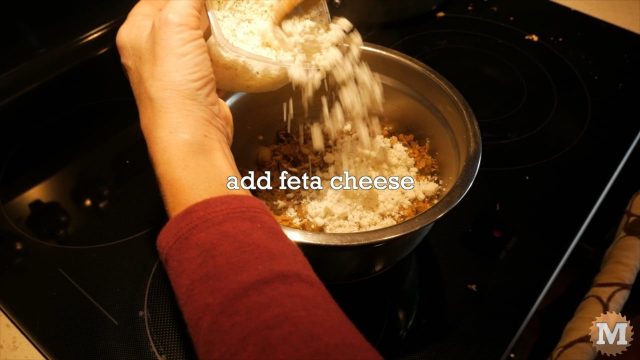 Adding feta cheese to the Winter Chanterelle Mushroom tart filling