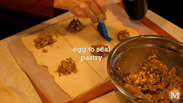 Brushing on egg mixture to seal the wild mushroom tart pastry
