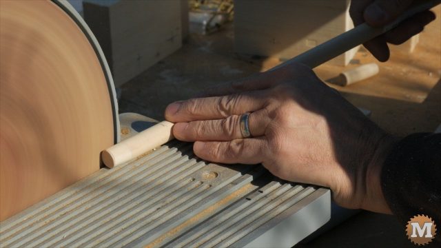 cutting wooden dowel on a saw