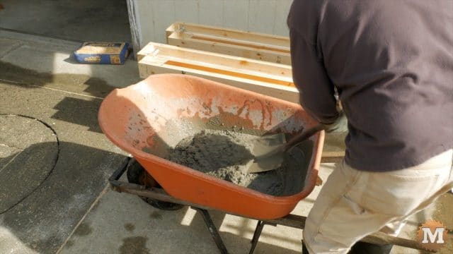 mixing concrete by hand with shovel and wheelbarrow