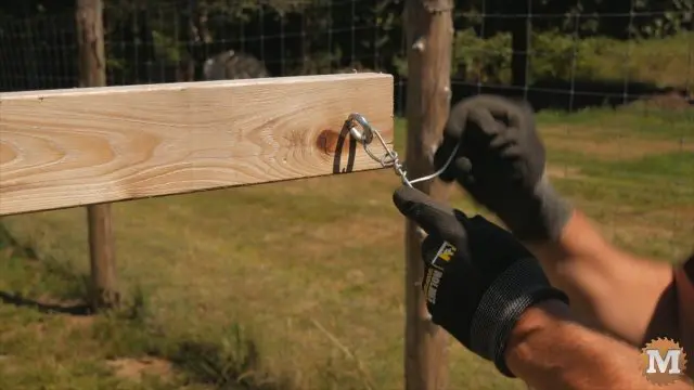tying galvanized wire to ring bolts on trellis