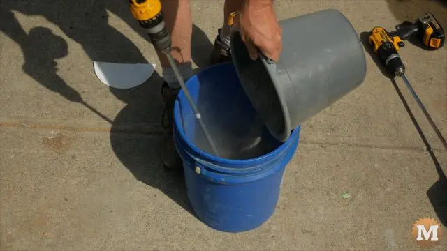Slowly adding portland cement and glass fiber to water in the pail