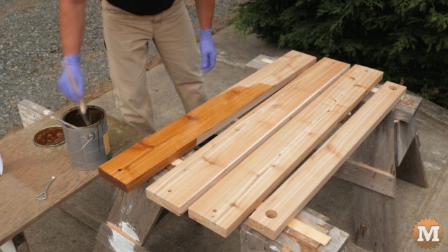 Staining the red cedar of the Garden Bench