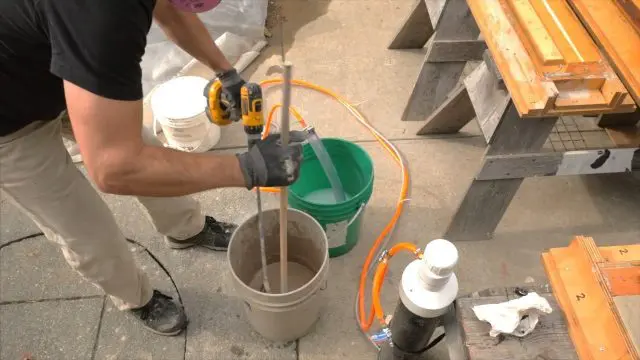 using a dowel to scrap mix off the side of the pail