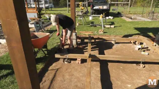 Shovelling wet concrete into tub for deck foundation
