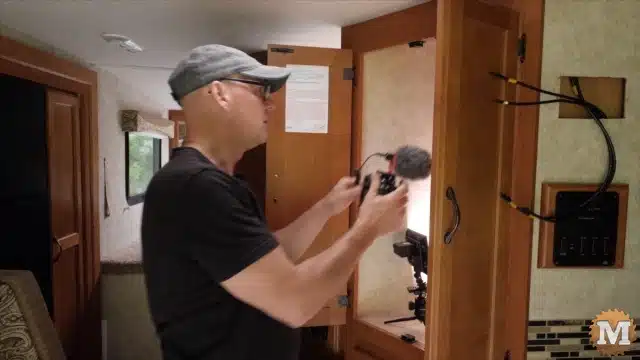 Kent using multiple cameras and lights to get the shot of the back of the closet where the solar charge controller and solar disconnect are mounted
