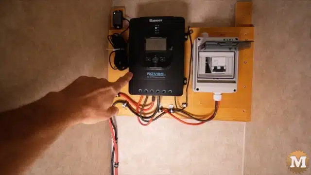 MPPT solar charge controller and disconnect box secured to the back of the closet on a piece of plywood