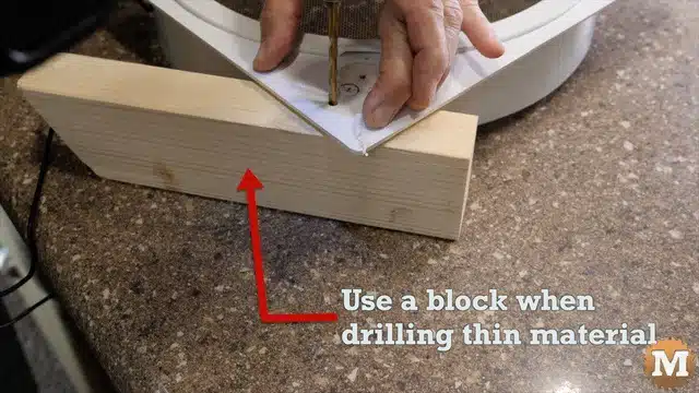 using a block of wood while drilling in thin plastic