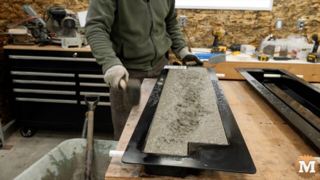 tapping the bench with a rubber mallet to further settle the concrete and bring trapped air to the surface