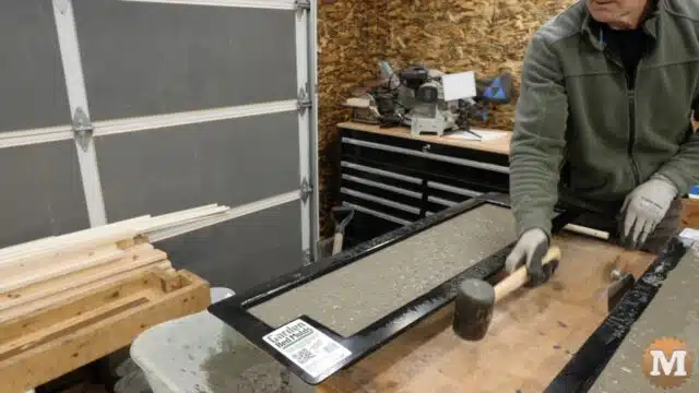 a rubber mallet is used to vibrate the workbench and settle the concrete