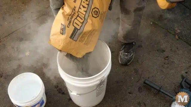 dry concrete mix is poured into the pail
