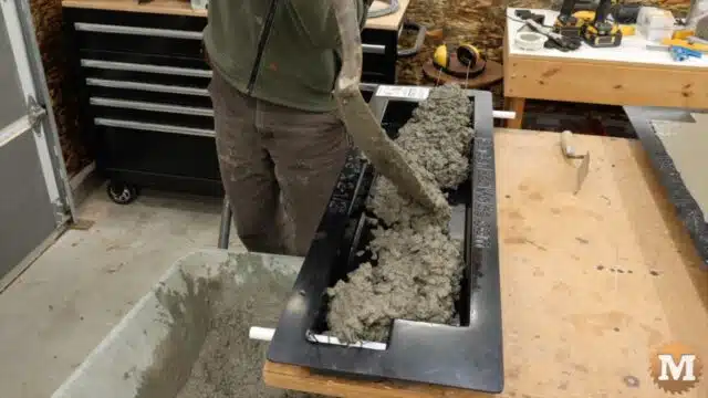 adding concrete to the mold with a shovel