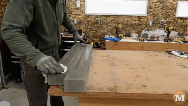 wiping any excess oil from the fresh concrete casting