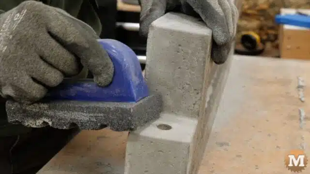 using the smooth edge of a concrete rub brick tool to dress the castings