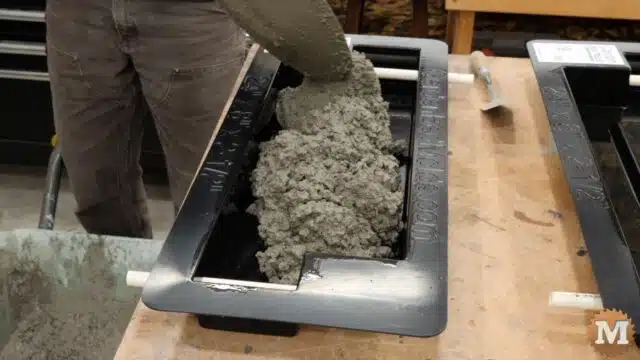 shovelling wet concrete into the 24" form