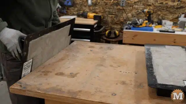 rotating the loaded plastic mold while maintaining contact with the work bench