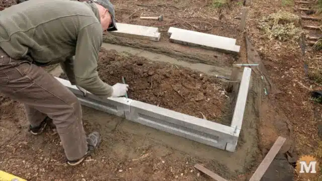 sliding rebar into aligned holes on the wall of the concrete garden bed