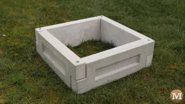 a square raised garden bed made from four 24" concrete panels