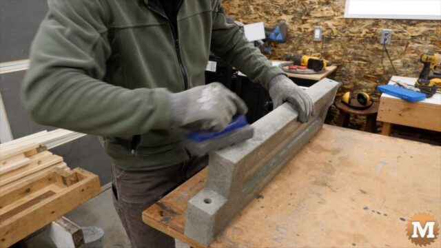 using a rub brick took to smooth edges of poured concrete panel